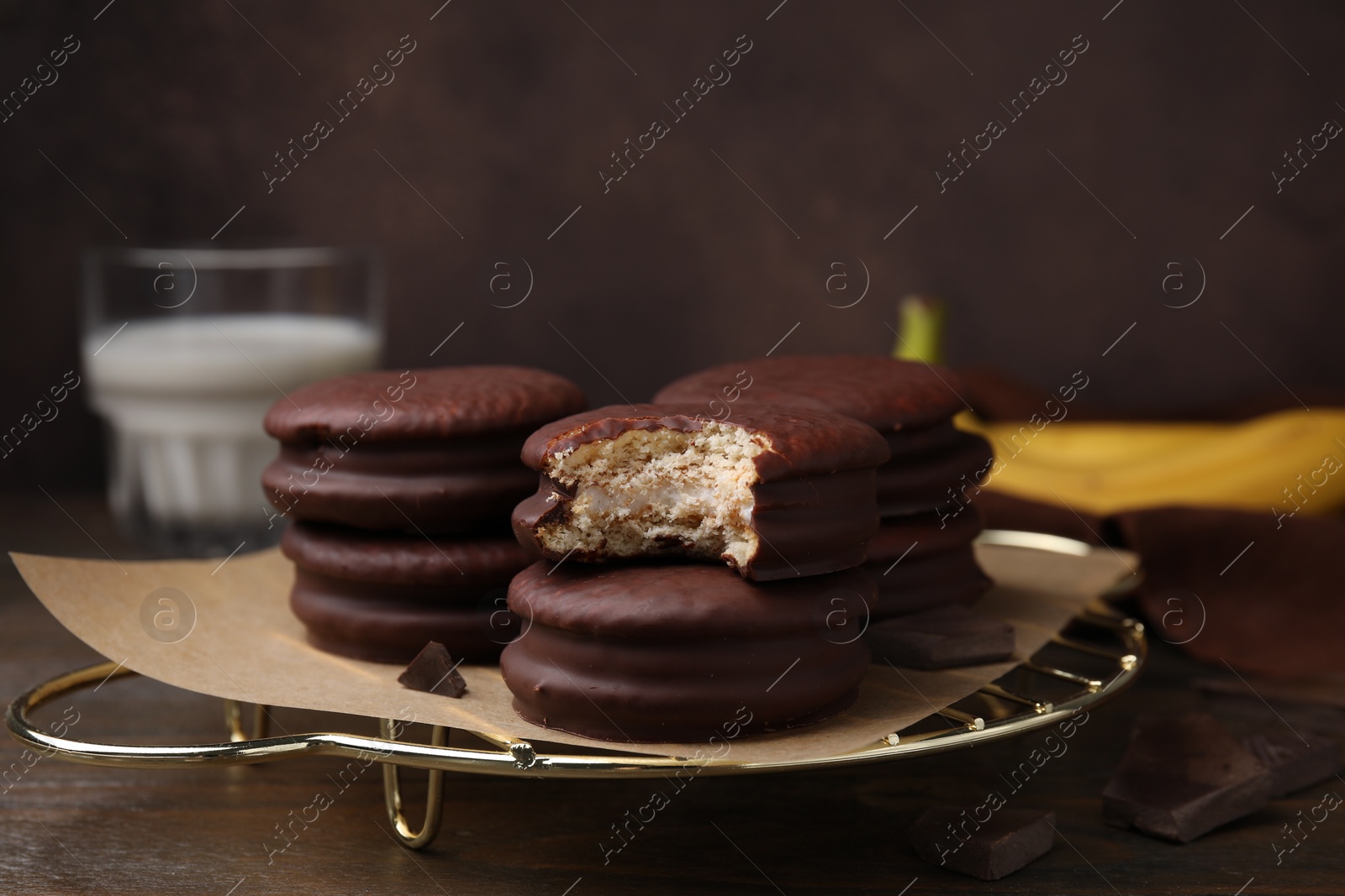 Photo of Delicious banana choco pies on wooden table, closeup