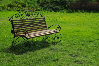 Beautiful wooden bench in park on sunny day