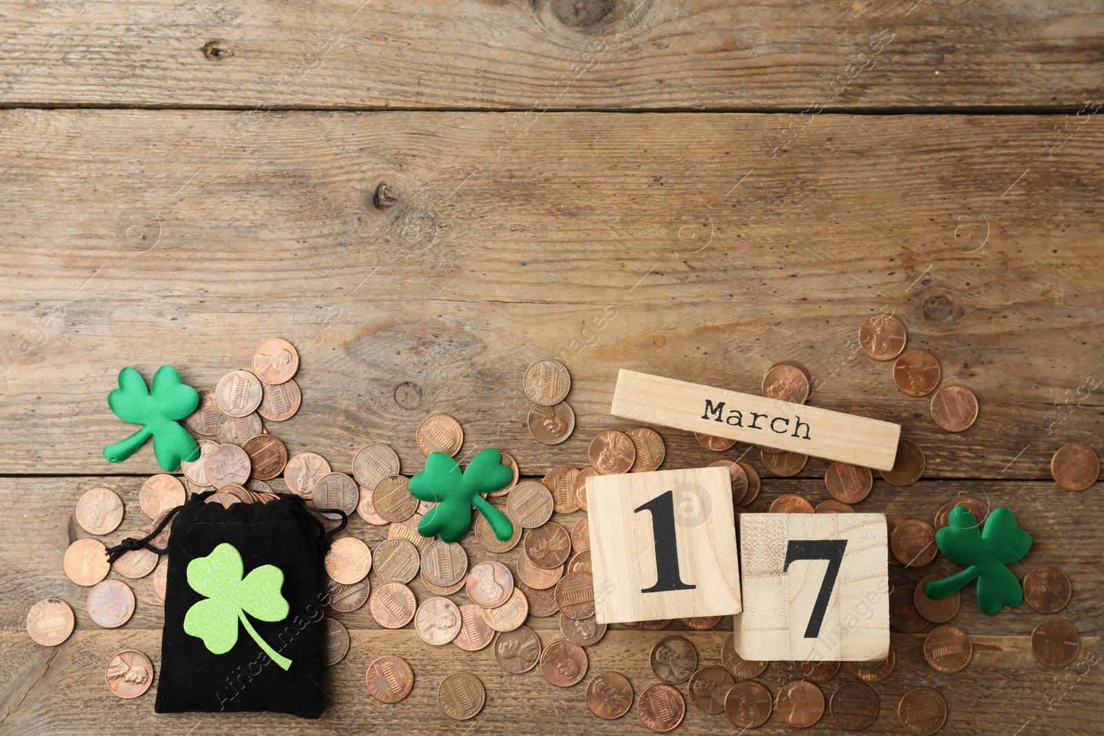 Photo of Flat lay composition with block calendar on wooden background, space for text. St. Patrick's Day celebration