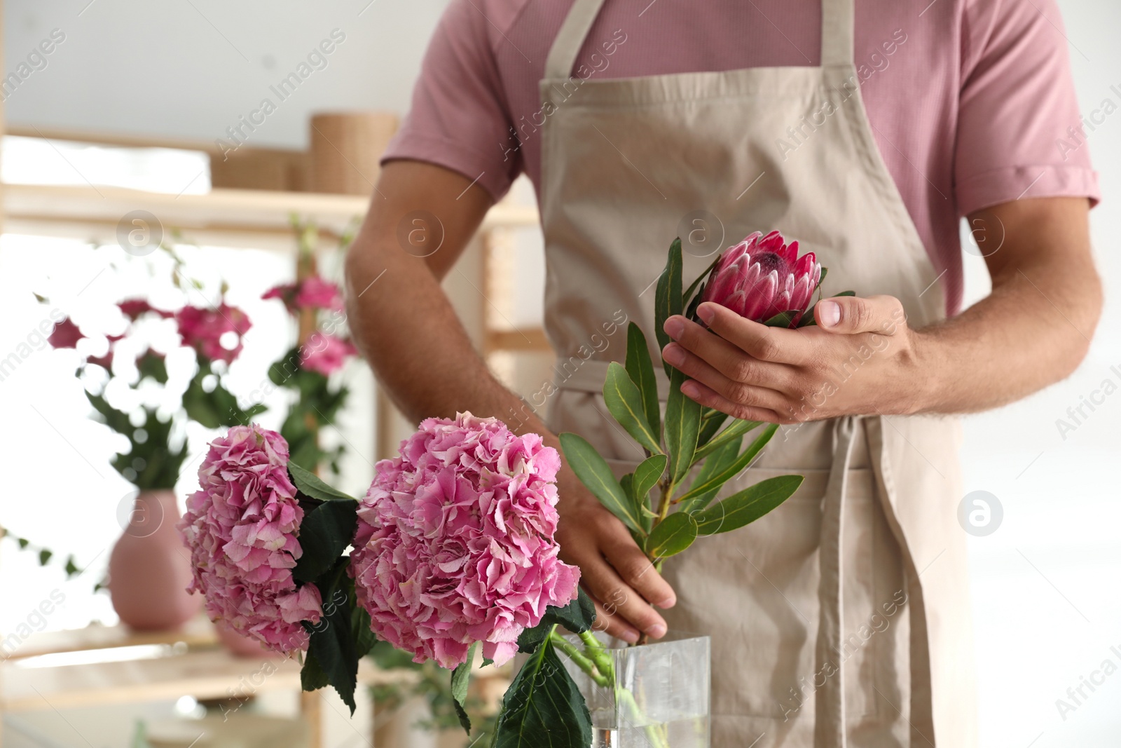 Photo of Florist with beautiful flowers in workshop, closeup