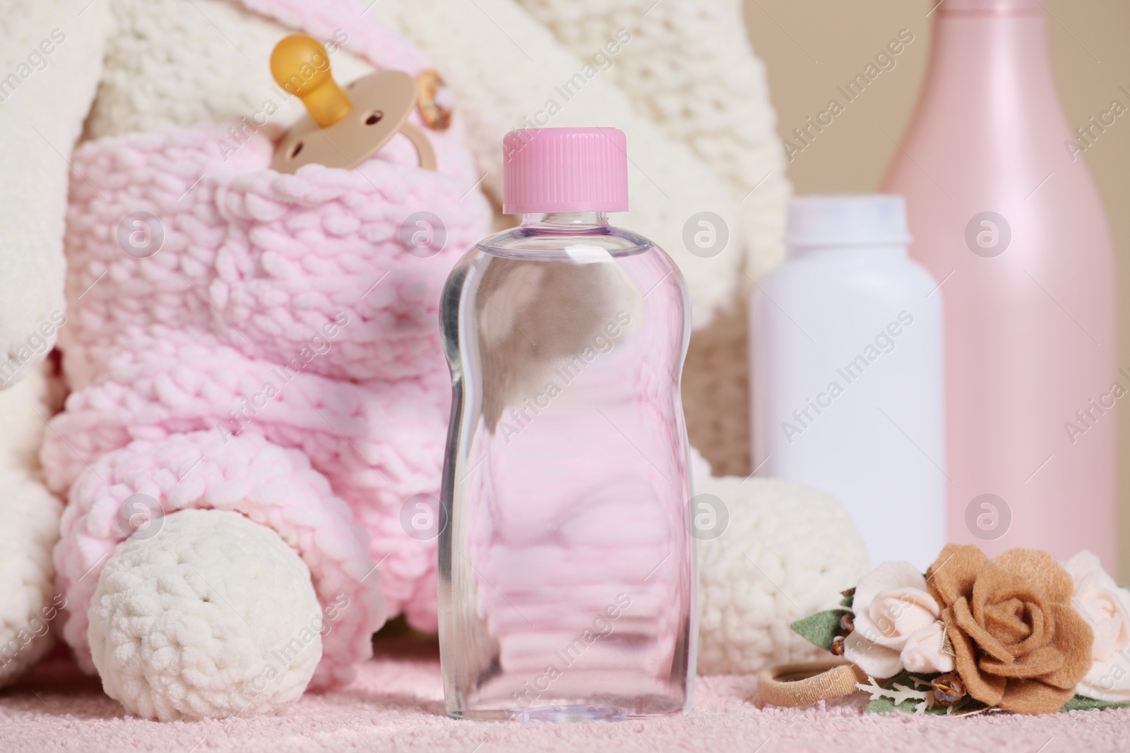 Photo of Baby cosmetic products and accessories on pink towel