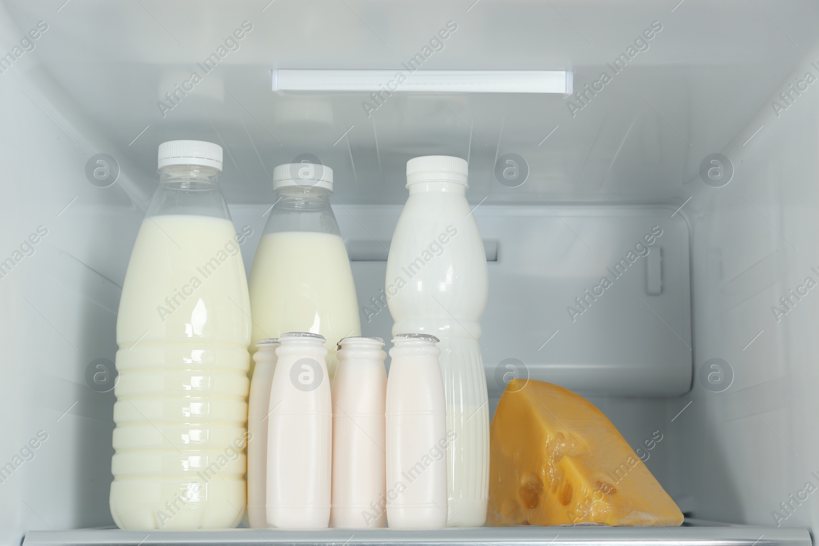 Photo of Bottles of dairy products on shelf in refrigerator