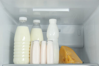 Bottles of dairy products on shelf in refrigerator