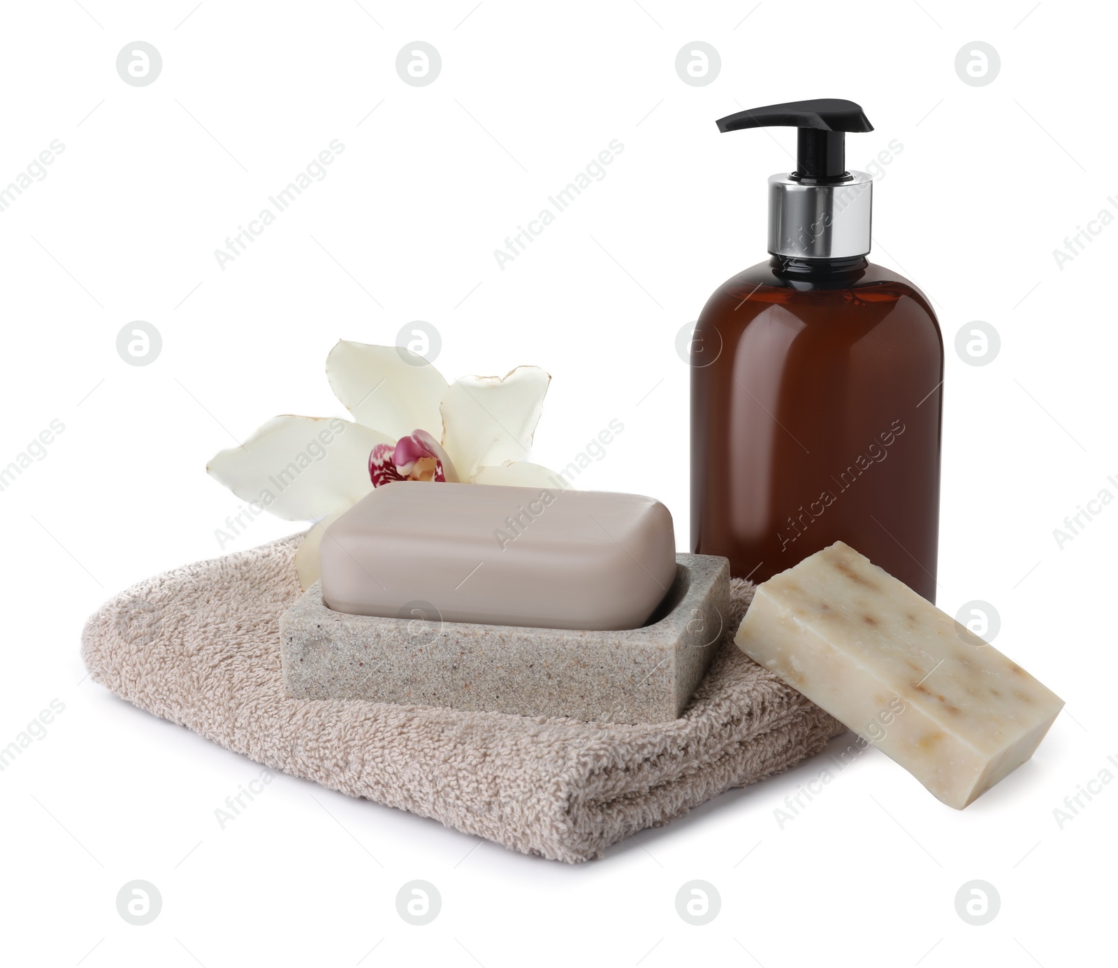 Photo of Soap bars, dispenser and terry towel on white background