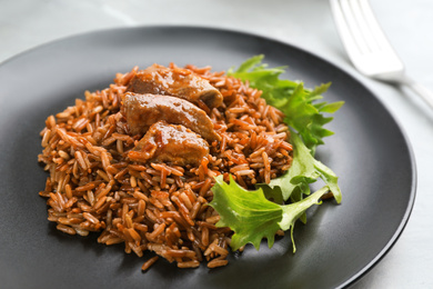 Photo of Tasty brown rice with meat on table, closeup