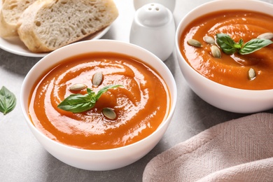 Photo of Bowls of tasty sweet potato soup served on table