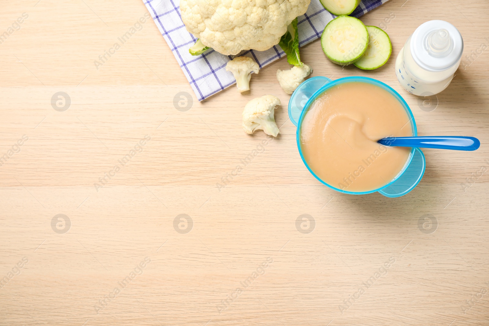 Photo of Healthy baby food and ingredients on wooden table. Space for text