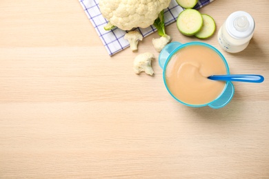 Photo of Healthy baby food and ingredients on wooden table. Space for text