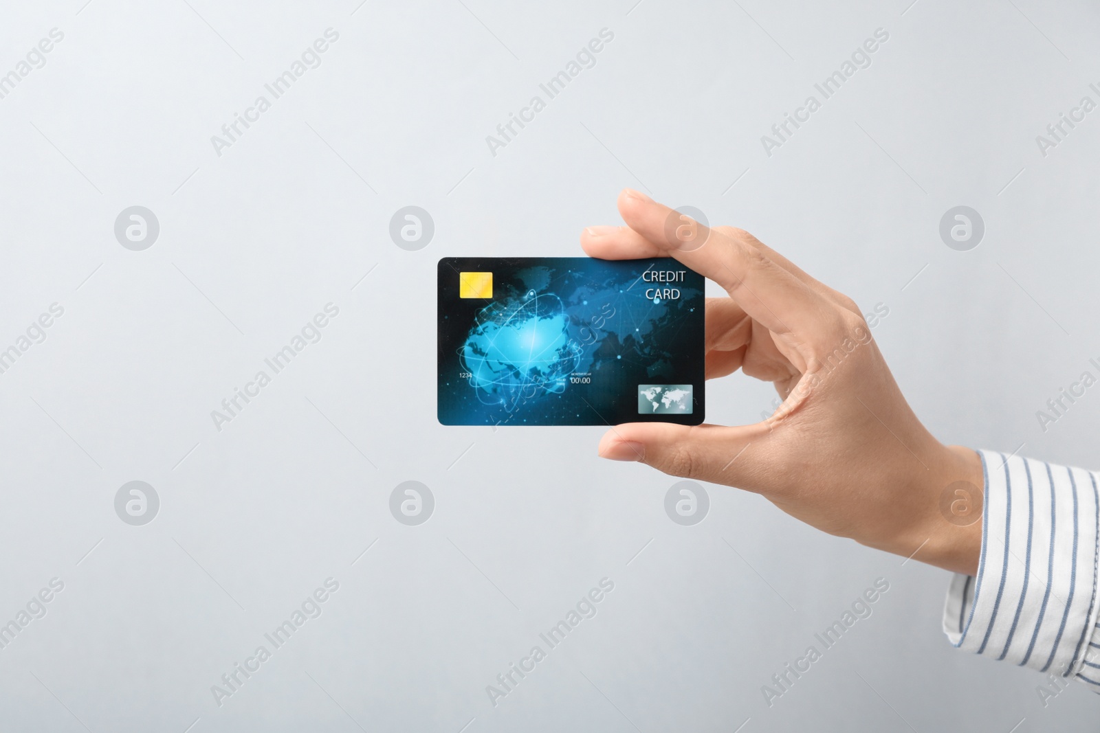 Photo of Woman holding credit card on light background