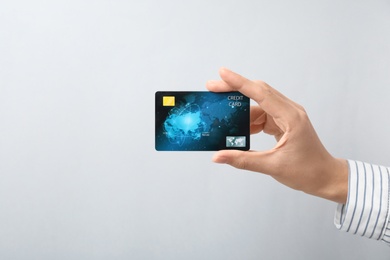 Photo of Woman holding credit card on light background