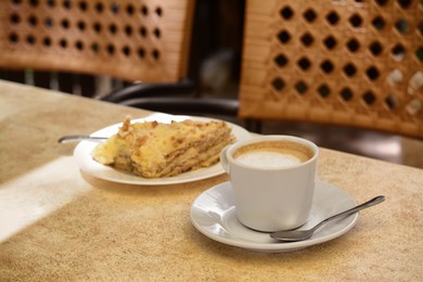 Photo of Piece of delicious cake and coffee on beige table