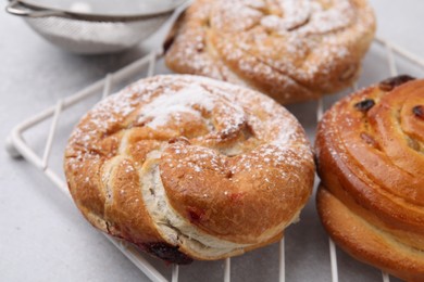 Different delicious rolls on light table, closeup. Sweet buns