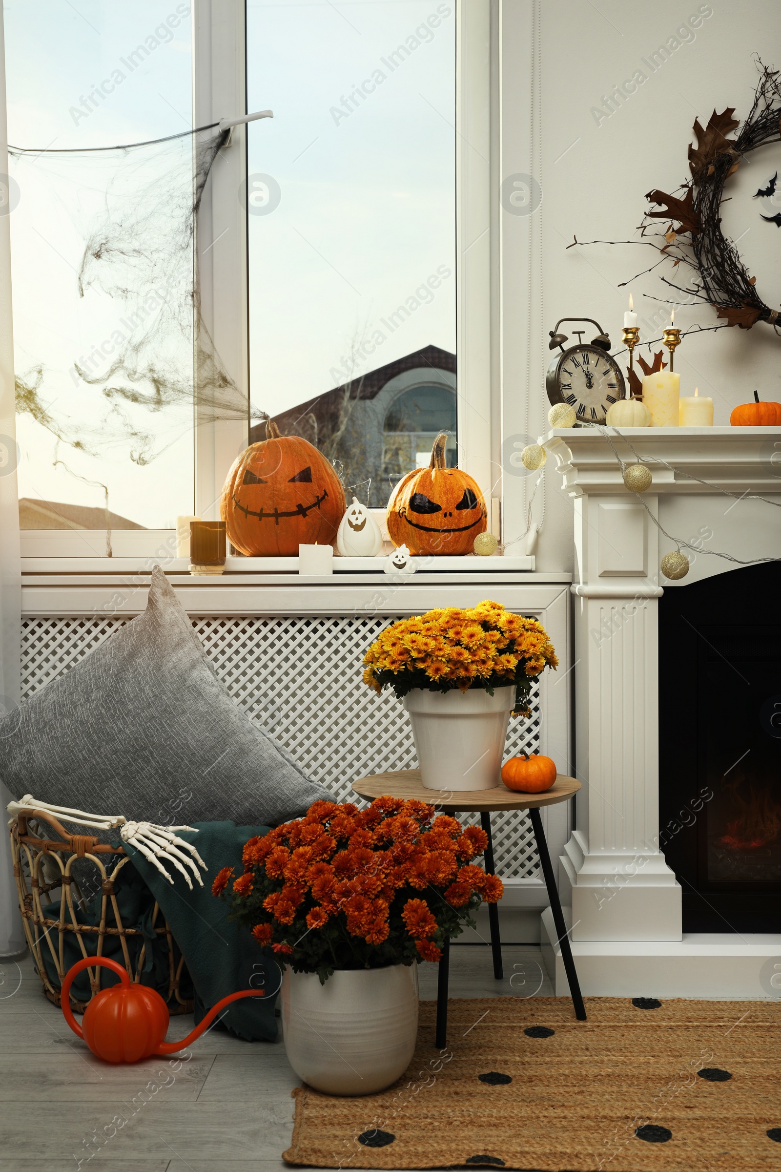 Photo of Modern room with fireplace decorated for Halloween. Festive interior