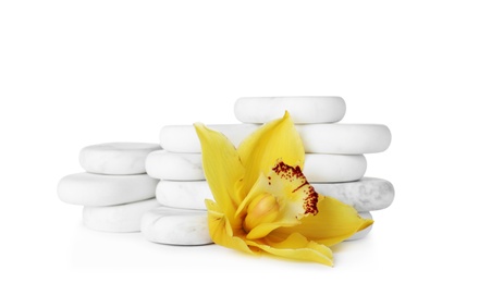 Photo of Stacked spa stones and beautiful orchid on white background