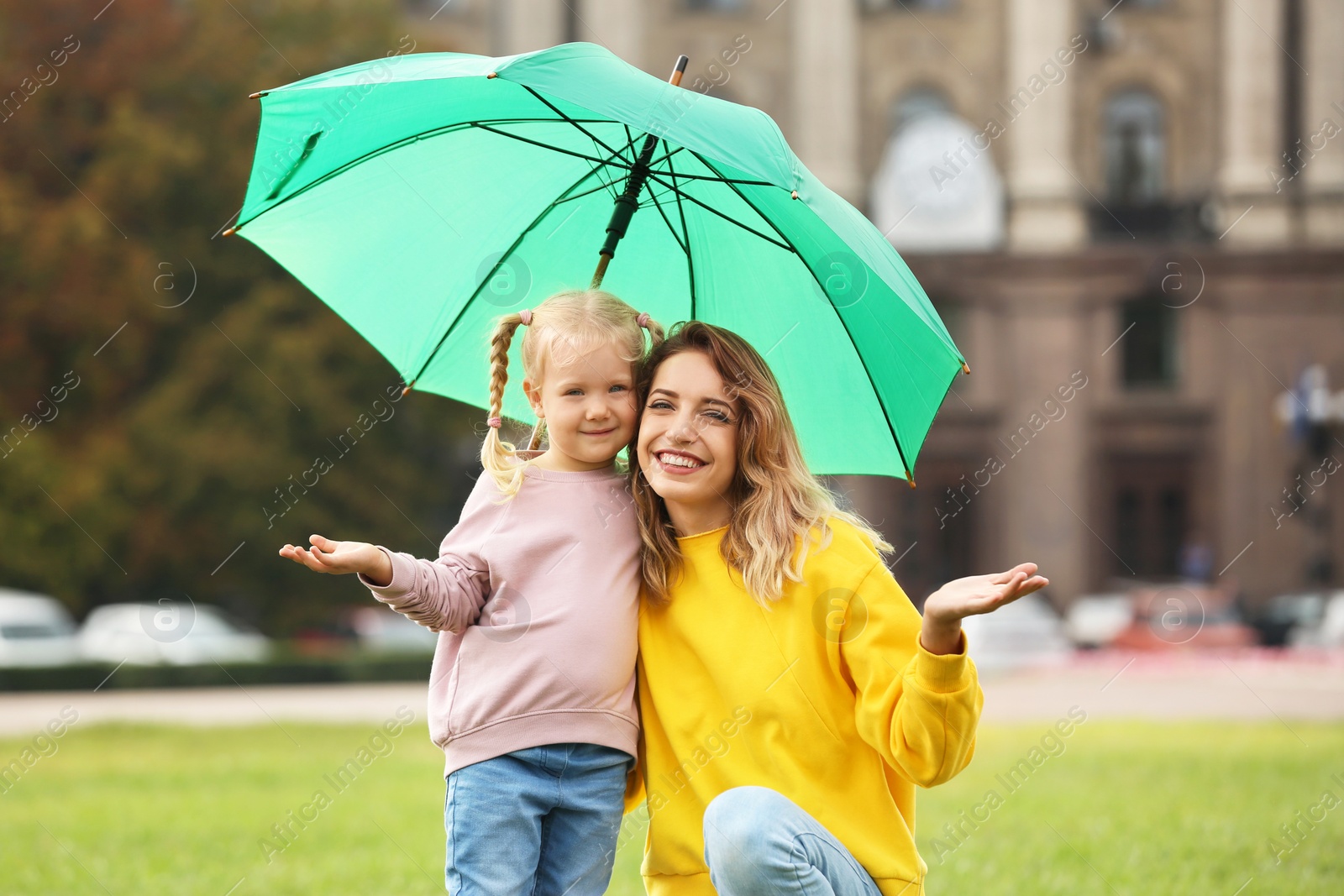 Photo of Happy mother and daughter with umbrella in park