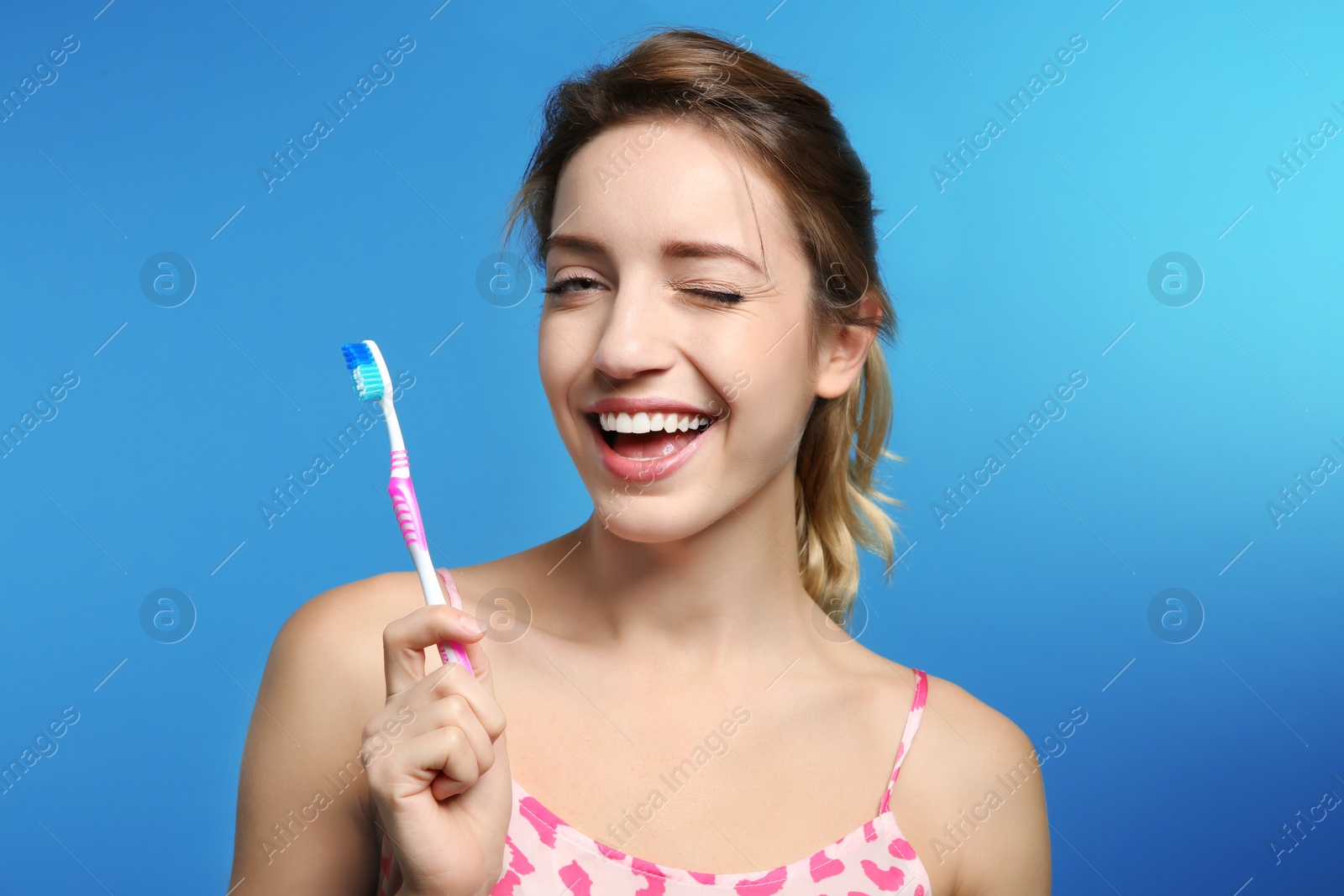 Photo of Portrait of young woman with toothbrush on color background