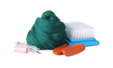 Photo of Green felting wool, finger protectors, brush and container with needles isolated on white