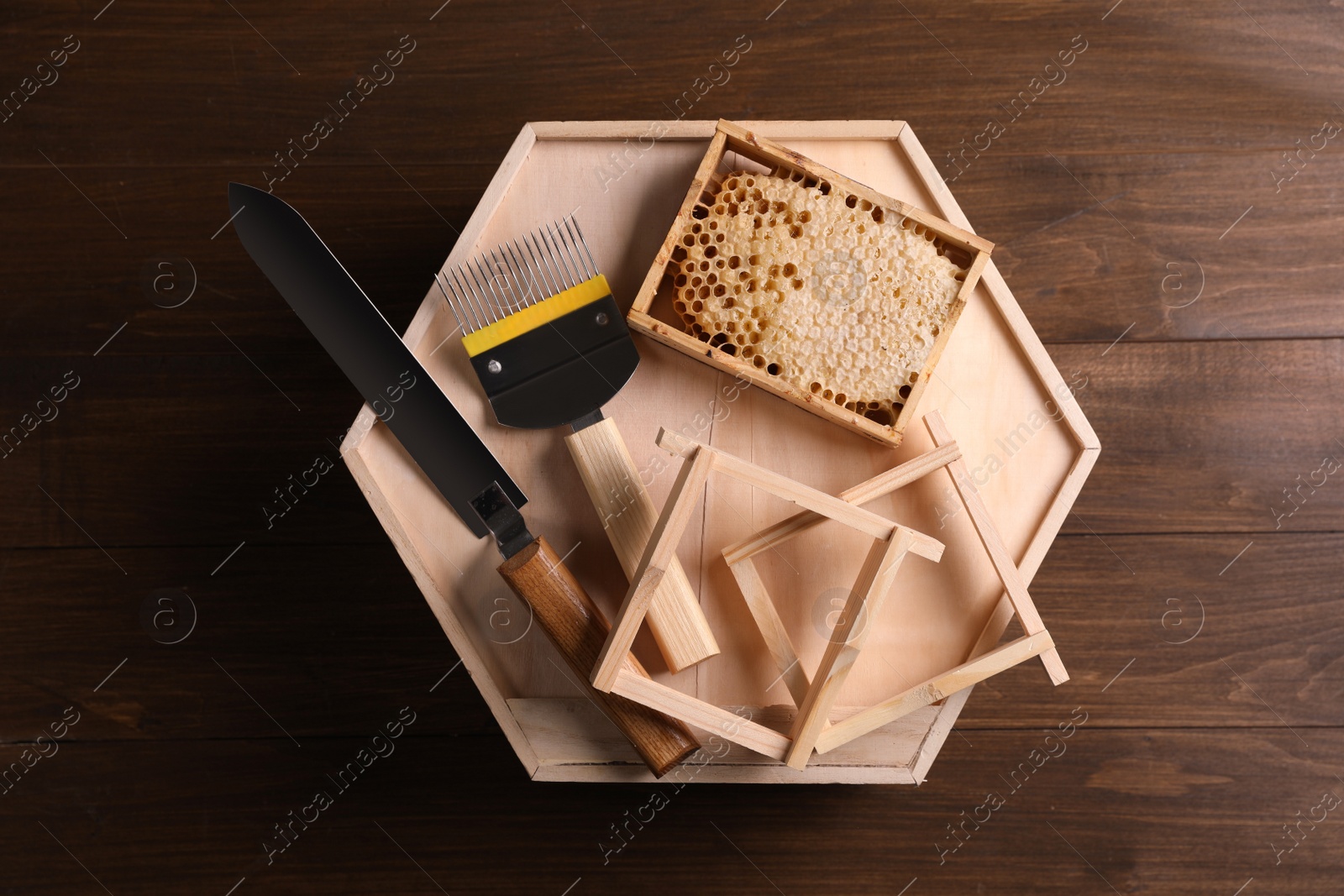 Photo of Honeycomb frames and beekeeping tools on wooden table, top view