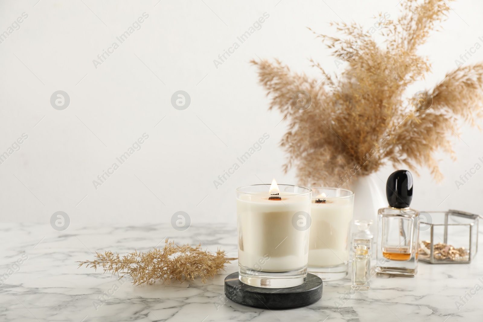 Photo of Composition with burning soy candles on white marble table, space for text