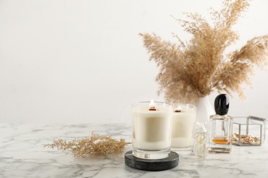 Photo of Composition with burning soy candles on white marble table, space for text