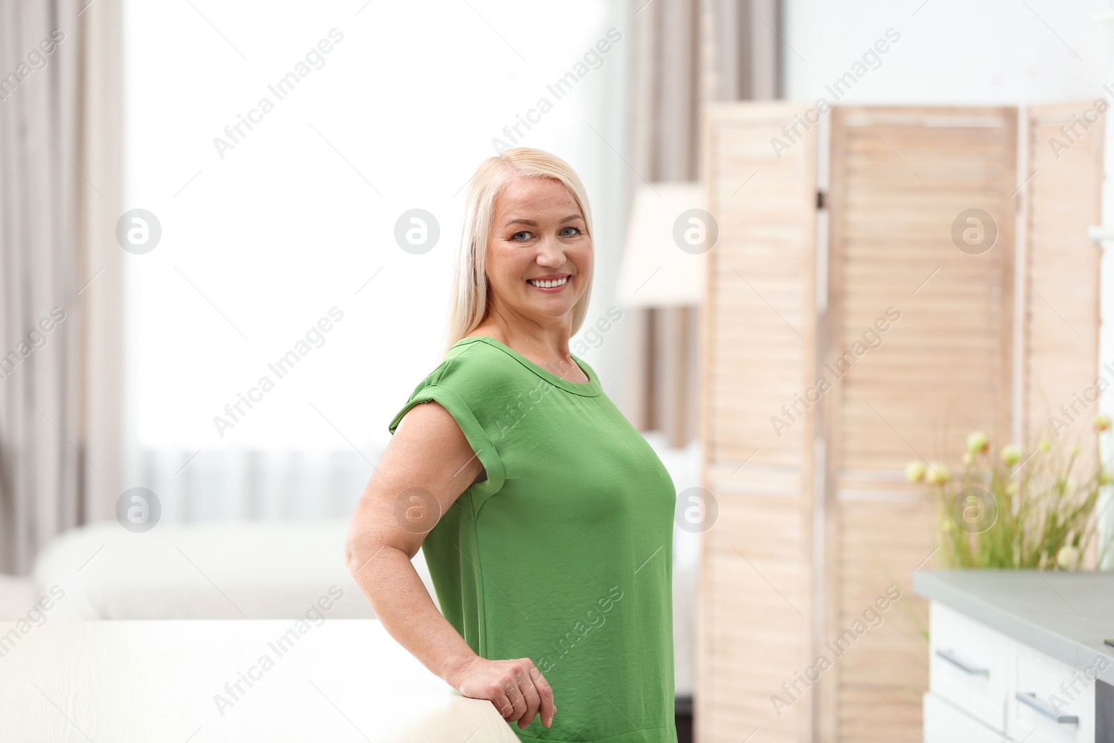 Photo of Portrait of happy mature woman at table indoors