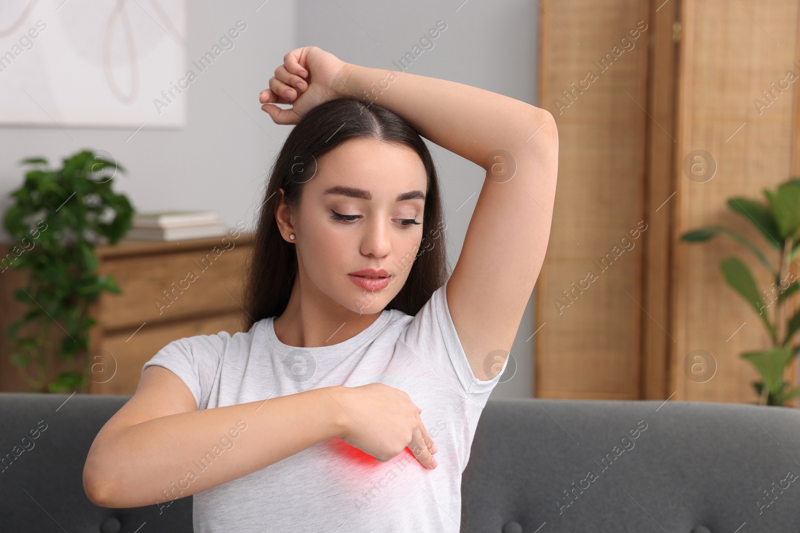 Image of Beautiful young woman doing breast self-examination at home, space for text