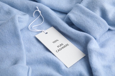 Image of Warm light blue cashmere sweater with label, closeup