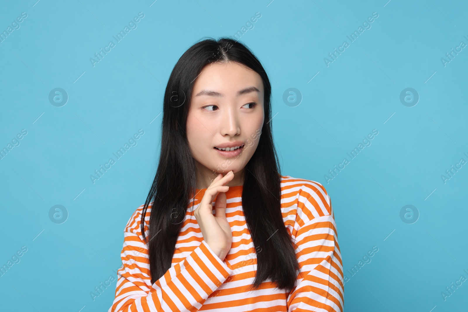 Photo of Portrait of cute woman on light blue background