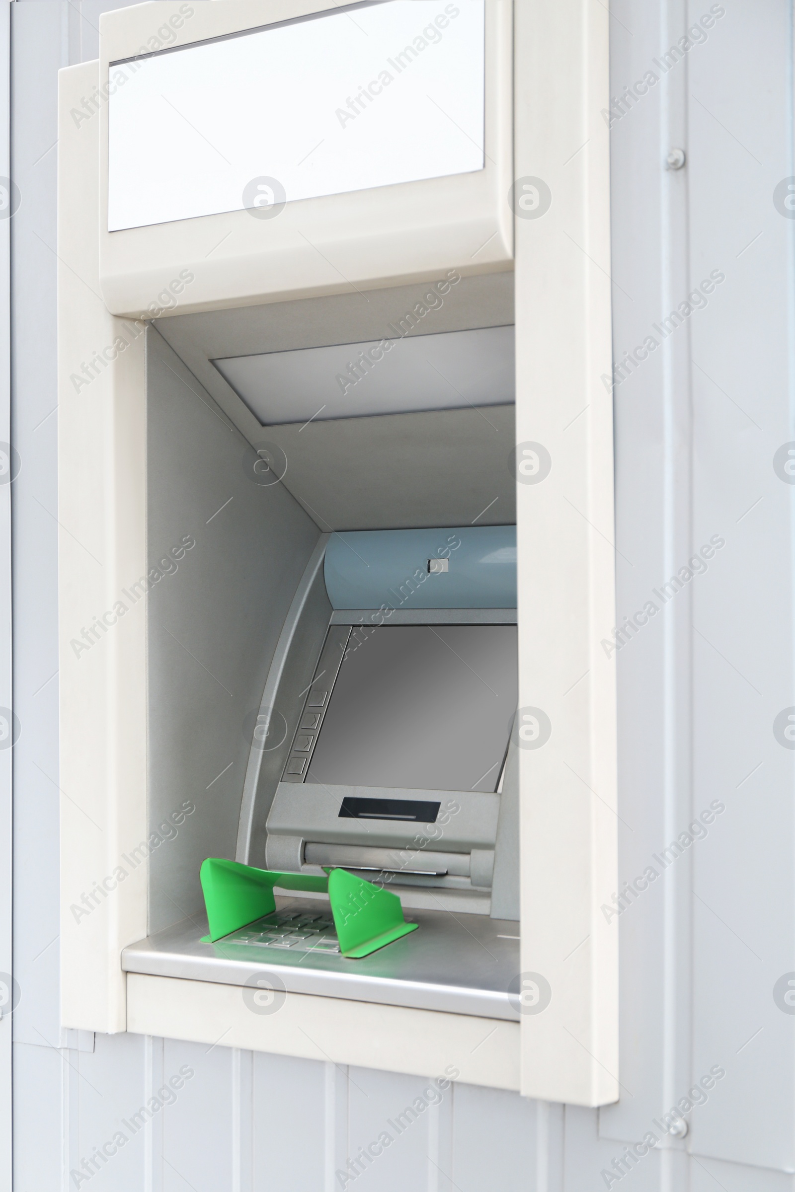 Photo of Modern automated cash machine with screen outdoors