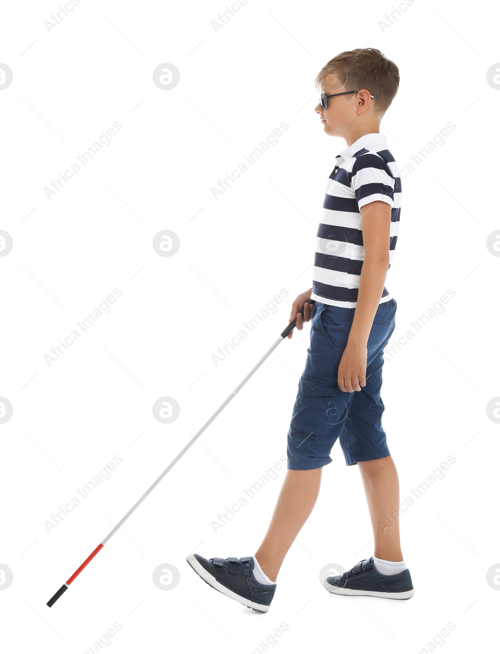 Photo of Blind boy with long cane walking on white background