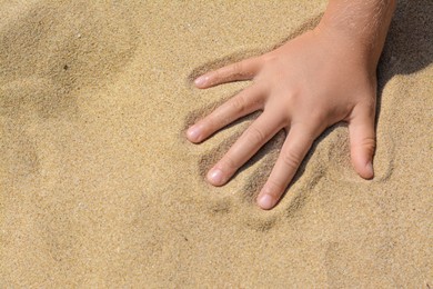 Photo of Child leaving handprint on sand outdoors, closeup with space for text. Fleeting time concept
