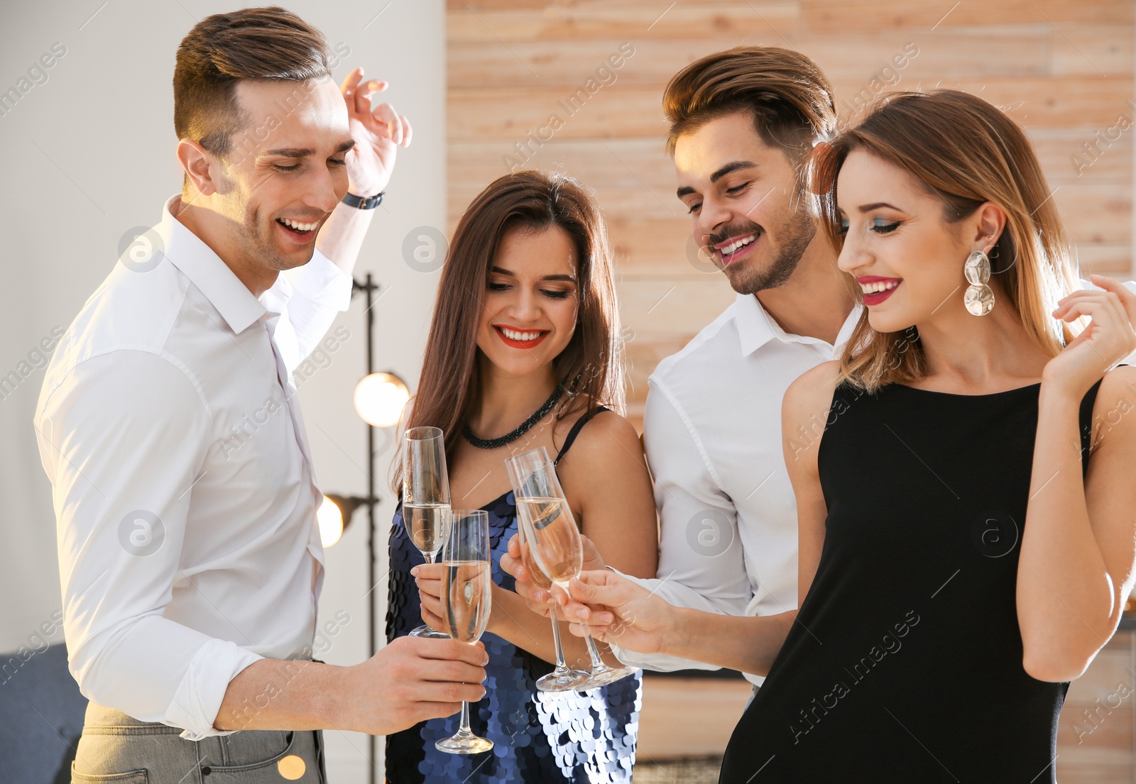 Photo of Friends clinking glasses with champagne at party indoors