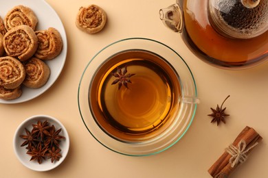 Flat lay composition with aromatic tea, cookies and anise stars on beige table