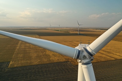 Photo of Modern windmill in wide field, closeup. Energy efficiency