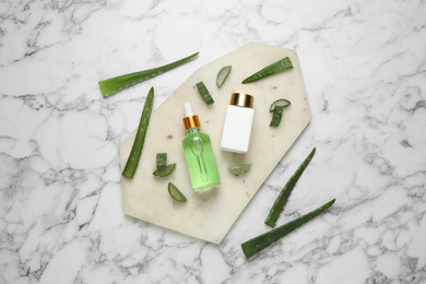 Flat lay composition with aloe vera and cosmetic products on white marble background