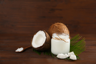 Photo of Composition with organic coconut oil on wooden table. Healthy cooking