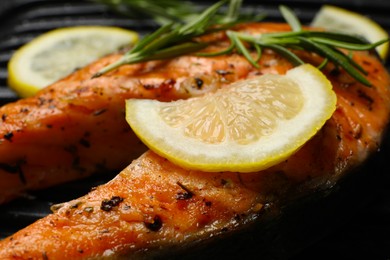 Photo of Cooking salmon. Grill with tasty fish steak, lemon and rosemary, closeup