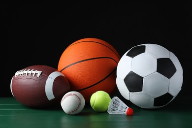 Photo of Set of different sport balls and shuttlecock on green wooden surface