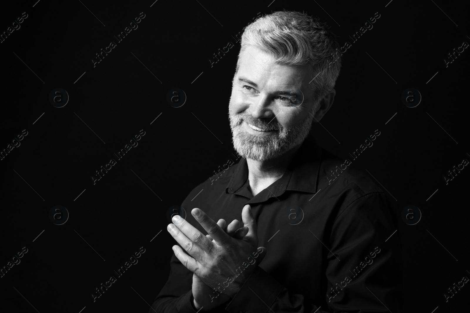 Photo of Portrait of smiling man on dark background, space for text. Black and white effect