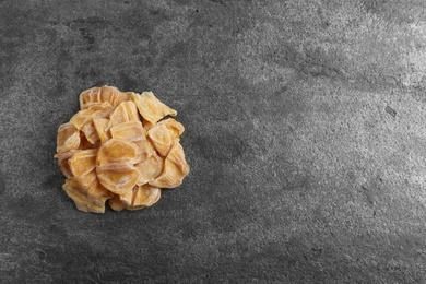Delicious dried jackfruit slices on dark grey table, top view. Space for text