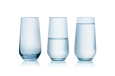 Photo of Empty, half full and full glasses of water on white background