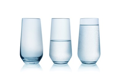 Empty, half full and full glasses of water on white background