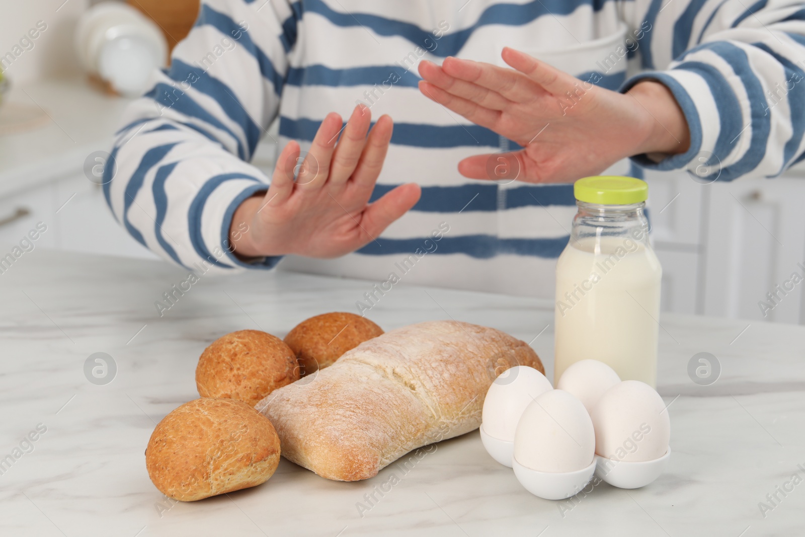 Photo of Woman suffering from food allergies refusing eat different fresh products at light marble table indoors, closeup