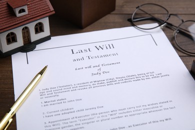 Photo of Last will and testament near house model, glasses with pen on table, closeup
