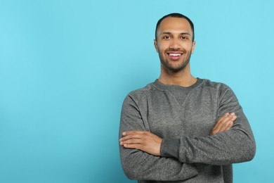 Photo of Portrait of handsome young man on light blue background, space for text