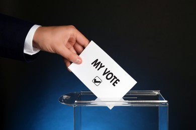 Image of Man putting paper with text My Vote and tick into ballot box on dark blue background