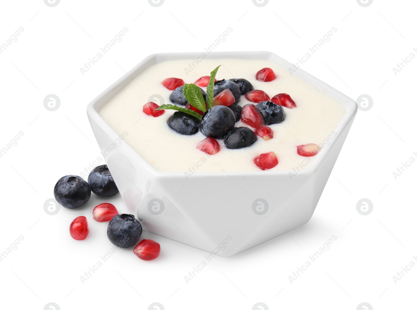 Photo of Bowl of delicious semolina pudding with blueberries, pomegranate and mint isolated on white