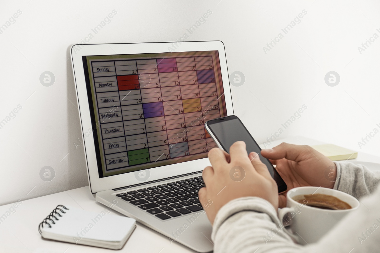 Photo of Young man using calendar app on laptop in office, closeup