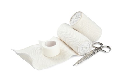 Photo of Medical bandage rolls, sticking plaster and scissors on white background