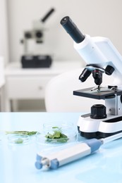 Photo of Food quality control. Microscope, petri dishes with herbs and other laboratory equipment on light blue table